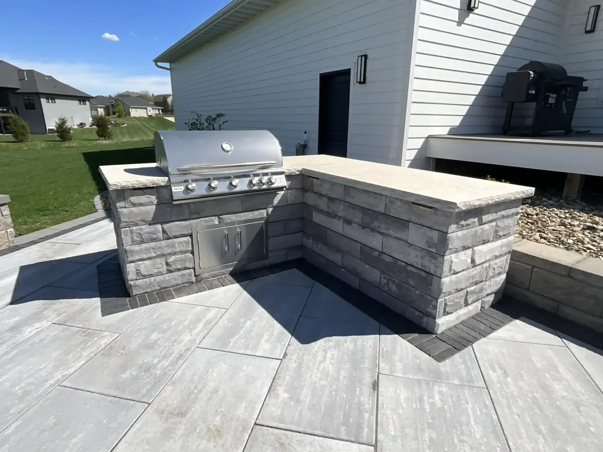 Outdoor kitchen with granite countertop and stone veneer base